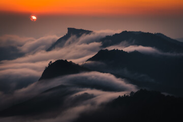 sunset behind the mountains with sea of cloud and beautiful sky in the northern of Thailand (Phu Chi Dao Chiang Rai Province)