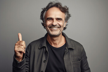 Portrait of middle age man grinning thumb up, neutral background