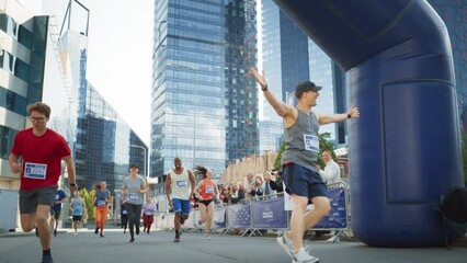 Slow Motion Portrait of a Smiling Group of People Participating in a City Marathon. Wide Shot of Diverse Race Runners Reaching the Finish Line, Celebrating Their Victory and Achieving their Goal