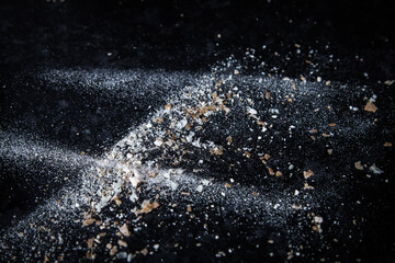 Abstract image made with flour and breadcrumbs on dark background. Conceptual image, alluding to space and cosmos, the unknown, light and darkness.