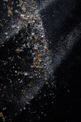 Abstract image made with flour and breadcrumbs on dark background. Conceptual image, alluding to space and cosmos, the unknown, light and darkness.