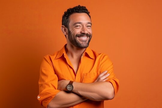 Portrait of a smiling handsome man in orange shirt on orange background