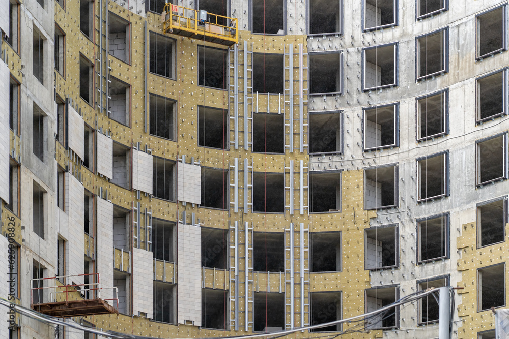 Poster installation of external wall thermal insulation with rock wool. monolithic concrete frame of apartm