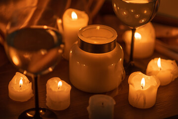 Lots of candles burning in the dark and two glasses of white wine. Romantic evening, date.