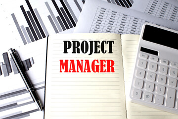 PROJECT MANAGER text written on a notebook on chart and diagram