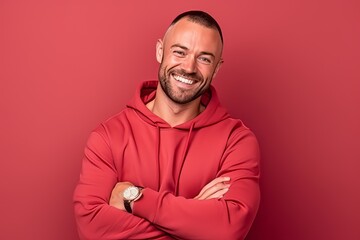 Portrait of a smiling man in a red hoodie on a red background