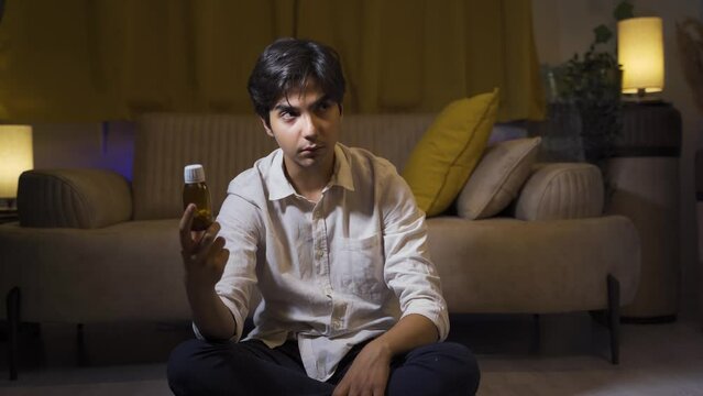 The man who looks at the pills in his hand and is going to commit suicide.