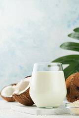 Glass of coconut milk and coconut close up on a white background with space for text. Coconut vegan milk non dairy or Dairy free milk concept. Healthy vegan food.