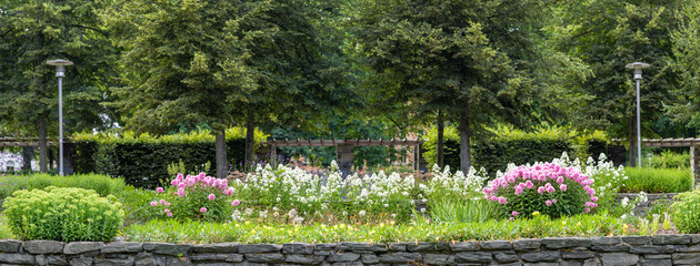 Panoramic view of a beautiful garden with colorful flowers during a summer European season