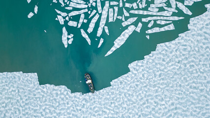 A cruising ship is anchored between pieces of ice in the arctic ocean near Svalbard. 
