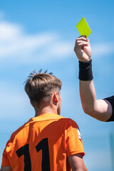 Soccer referre shows yellow card to the football player