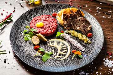 Beef tartare from Black Angus. Onion, quail egg, tomato sauce, mustard mayonnaise. Delicious healthy Italian traditional food closeup served for lunch in modern gourmet cuisine restaurant