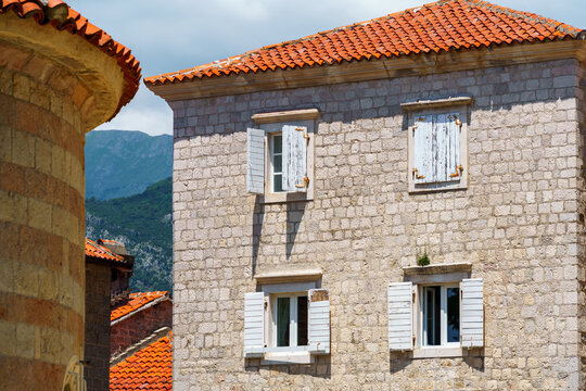 street view of the old town of Budva in Montenegro, medieval European architecture, city streets, windows with wooden shutters, red tiled roofs, the concept of traveling through the Balkans