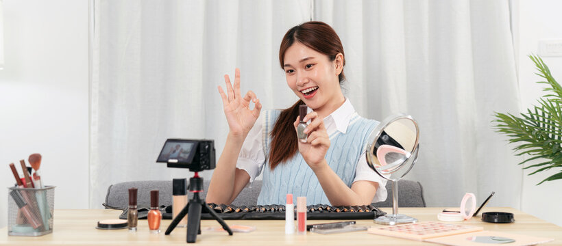 Young beauty influencer is showing to recommend nail polish product and making ok gesture while recording