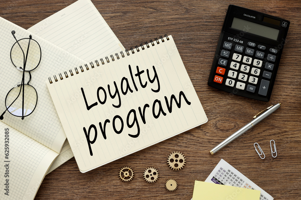 Poster glasses and a calculator lie on a notebook with words loyalty program