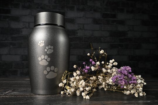 In remembrance of a pet. Pet urn beside a flower bouchet. 