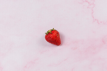 strawberries on pink marble background