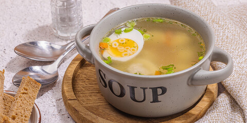Meatball soup with boiled egg, ditalini pasta, vegetables and fresh herbs. Healthy chicken broth
