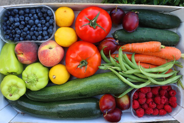 Wooden crate full of healthy colorful seasonal fruit and vegetable. Top view.