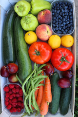Wooden crate full of healthy colorful seasonal fruit and vegetable. Top view.