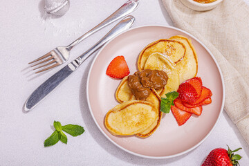 Cottage cheese pancakes, syrniki, curd fritters with strawberry, mint and powdered sugar on plate
