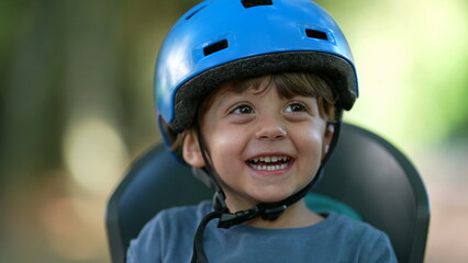 Fototapeta na wymiar Happy little boy wearing bicycle helmet laughing and smiling