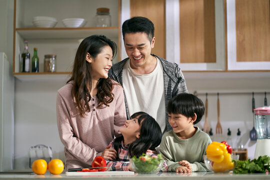 happy asian family with two children in kitchen at home