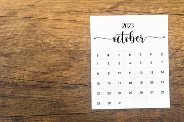 A October 2023 Monthly calendar for 2023 year on wooden background.
