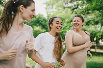 Happy women training in a park, jogging and having sport activity. Healthy lifestyle.