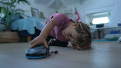 Naklejka premium Little boy playing with car toy in bedroom