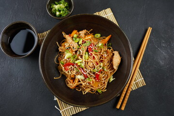 Stir fry noodles with vegetables and chicken meat in a bowl.
