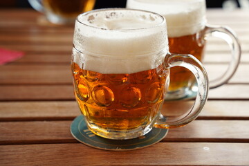 Czech-style Pilsner lager golden beer on table of bar pub restaurant in Prague, Czech Republic.