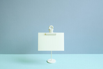 Blank memo pad and holder on blue desk. blue wall background