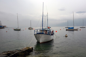 Fototapeta premium A variety of small sailing yachts are moored in the sea near the shore near the pier