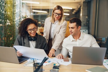 Group of business colleagues working together on project in modern coworking. Teamwork concept