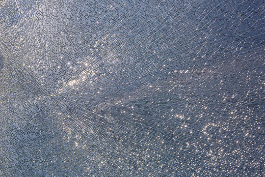 cracks at tempered glass, spoiled glass surface, texture background, blind windscreen close-up, nobody.