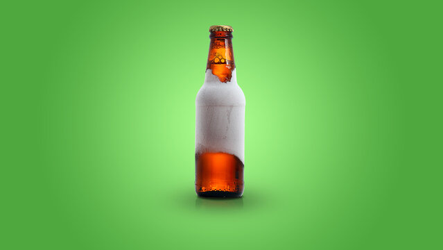 Garrafa de cerveja gelada em um fundo verde.