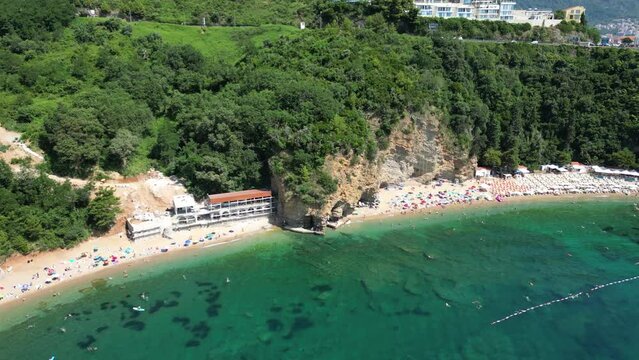 Beautiful top view of Mogren beach, clear sea and bathing people. Budva. Montenegro. Aerial view.