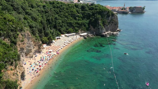 Beautiful top view of Mogren beach, clear sea and bathing people. Budva. Montenegro. Aerial view.