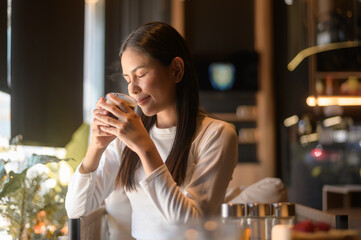A young woman drinking coffee in modern coffee shop