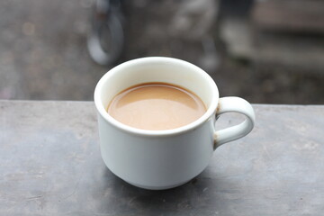 milk black coffee in vintage cup. Soft focus with dramatic light on a blurred background.