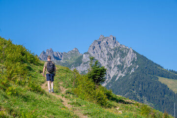 Fototapeta na wymiar Climbing the Bazorahang with the Three Sister Mountains on the background, Walgau Valley, State of Vorarlberg, Austria