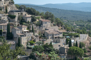 Fototapeta na wymiar Old medieval town Gordes on the rock, Luberon, Vaucluse, landscape of Provence France, Europe in july. Beautiful ancient buildings with roof tiles. 12th century houses. 