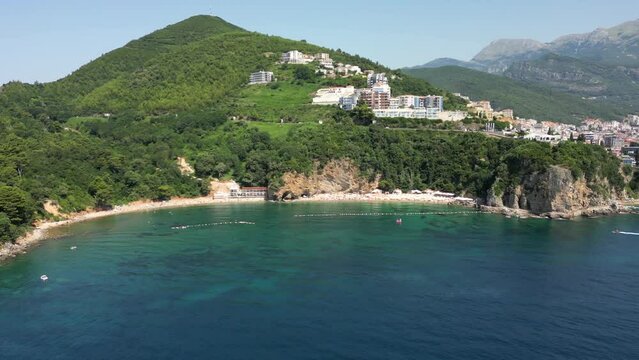 Beautiful top view of Mogren beach, clear sea and bathing people. Budva. Montenegro. Aerial view.