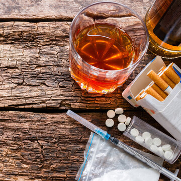 alcohol, cigarettes and drugs on wooden background template space for text