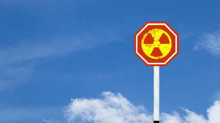 The radioactive symbol on red warning sign with blue sky background concept of beware of radioactive materials                               
