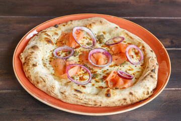 Pizza italienne au saumon faite maison dans une assiette en céramique. Gros plan. 