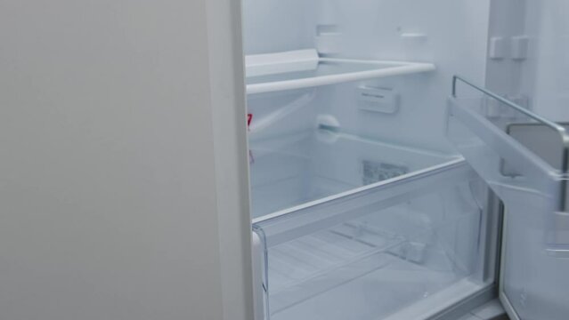 a hungry woman looks into the refrigerator and checks that it is empty. woman looking into an empty fridge