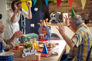 Cheerful happy family celebrating birthday together clapping and singing, little girl feeling happy...