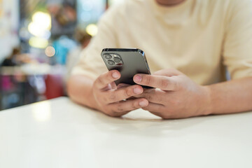 Relaxed young asian man using smart phone  spending time checking news social media.